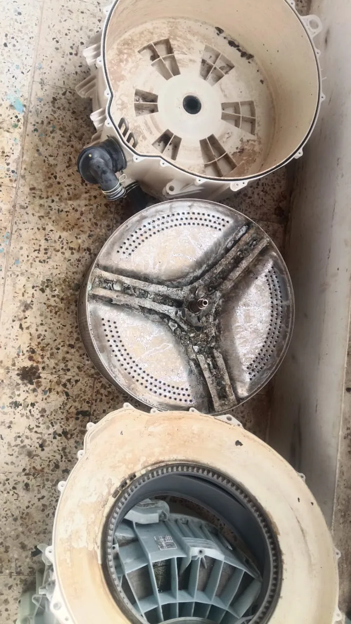Dirty disassembled washing machine components before cleaning
