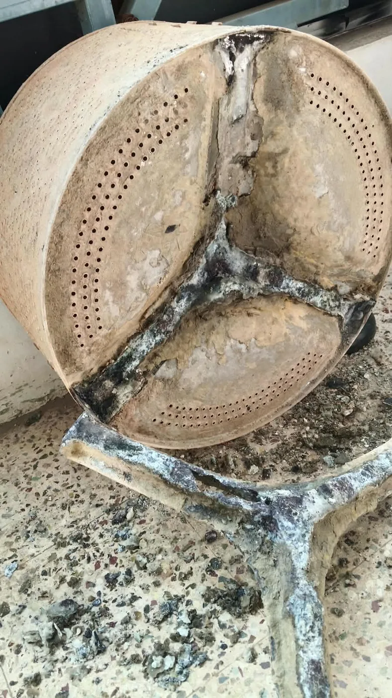 Dirty washing machine drum and tub during inspection